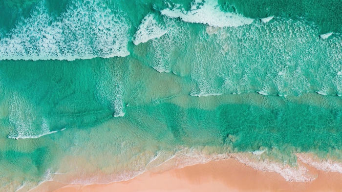 Aerial view of a beach with turquoise waves and sand
