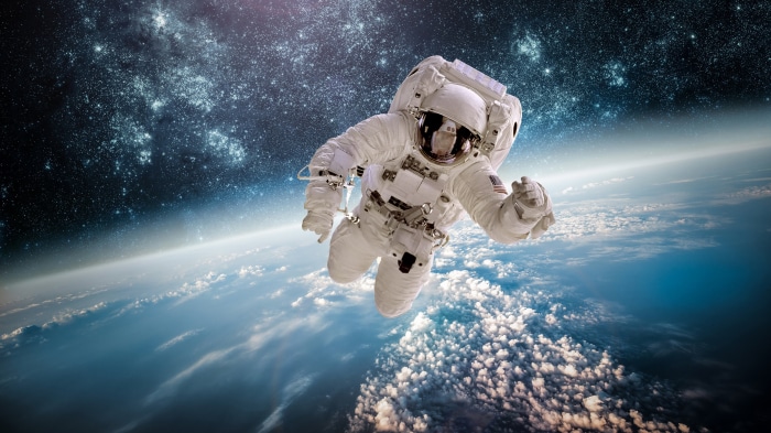 Astronaut floating above Earth in space 4K