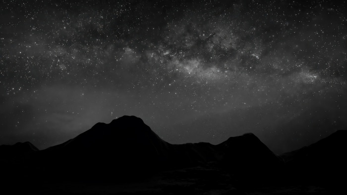 Monochrome night sky with Milky Way over mountains