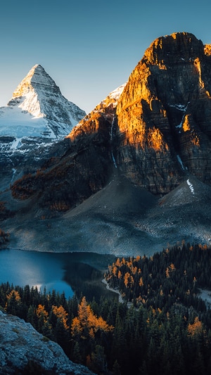 Snowy mountain range overlooking a lake and forest