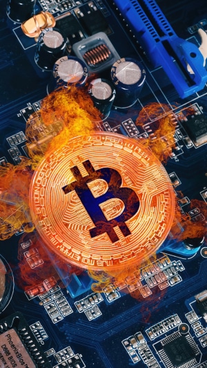 Bitcoin cryptocurrency on a computer circuit board with flames