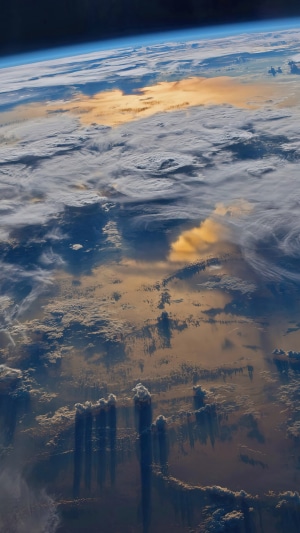 Earth from space with clouds and sunlight reflection