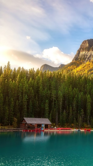 Cabin by a lake with forest and mountains