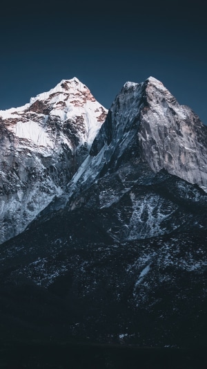 Snowy mountains against a dark blue sky