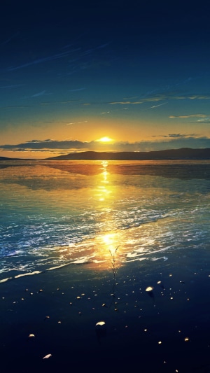 Sunset over a calm body of water with distant hills