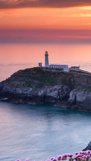 Lighthouse on a rocky coast at sunset