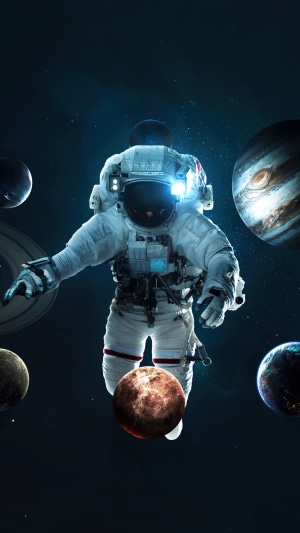 Astronaut floating among planets in space