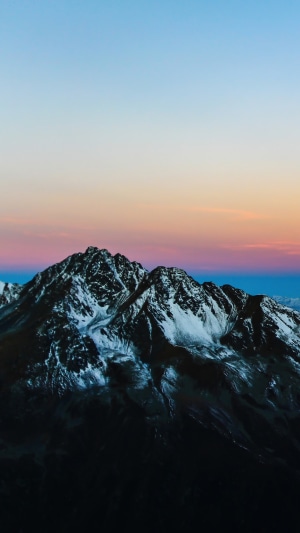 Snow-capped mountains at sunrise with colorful sky