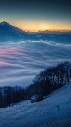 Mountain range above clouds at sunrise