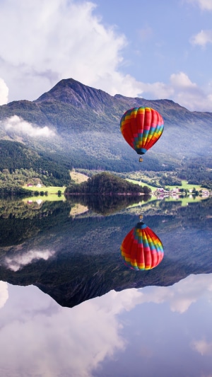 Hot air balloon over a lake with mountains