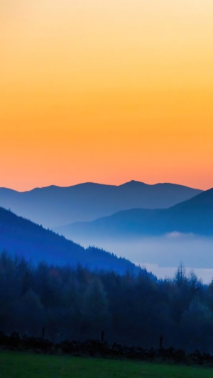 Layered mountains at sunset with fog