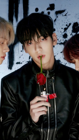 Soobin from TXT holding a rose and lighter