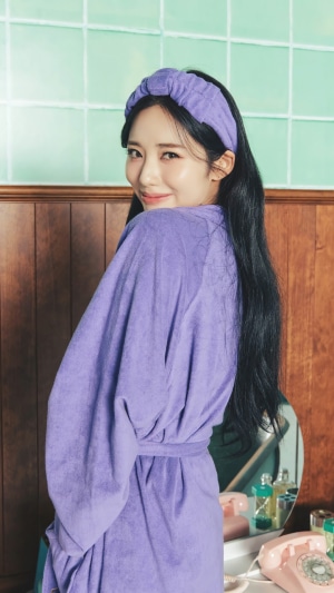 Jiwon from Fromis 9 wearing a purple bathrobe and headband