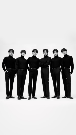 The K-pop group TNX poses for a black and white photo.
