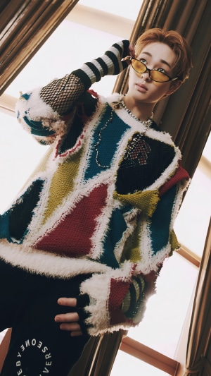 Onew from SHINee wearing a colorful sweater and sunglasses