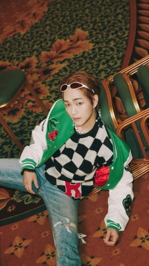 Onew Lee Jin-ki wearing a varsity jacket and checkered sweater