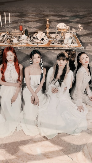 Dreamcatcher members in white dresses in front of a table