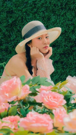Yeri from Red Velvet wearing a hat in a garden