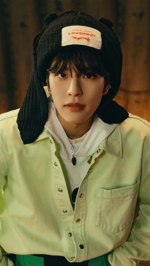 Seungmin from Stray Kids wearing a black hat and green shirt