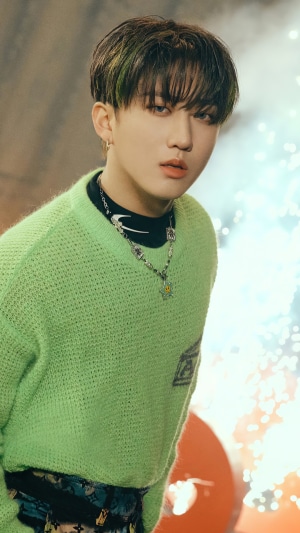 Changbin from Stray Kids wearing a green sweater