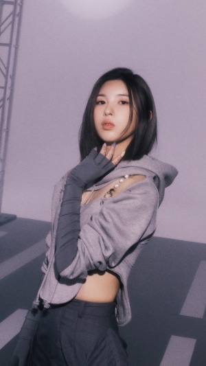 Bae Jin-sol from NMIXX posing in a grey hoodie