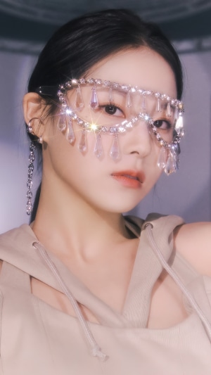 Kyujin from NMIXX wearing a jeweled mask