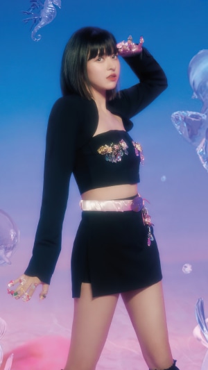 Lily from NMIXX in a black outfit with sea-themed decorations