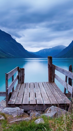 Wooden pier on a lake with mountains in Norway