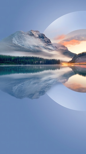 Snowy mountain reflected in a lake with forest