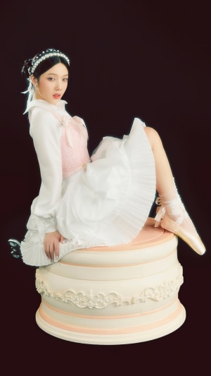 Joy from Red Velvet posing on a cake prop