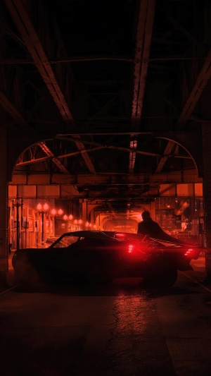 Batman in the Batmobile under a bridge