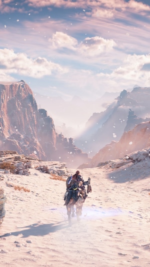 Aloy riding a mount through a snowy mountain landscape in Horizon Forbidden West
