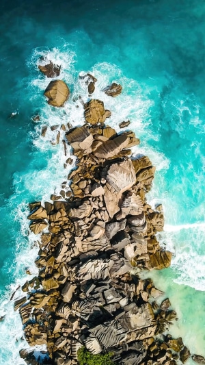 Aerial view of rocky coastline with turquoise waves