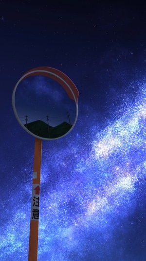 Road mirror reflecting mountains under a starry night sky