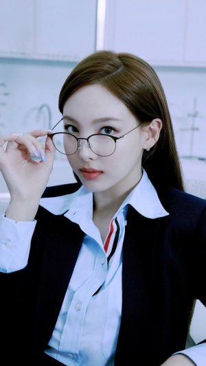 Nayeon from TWICE wearing glasses and a suit