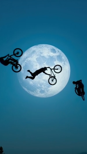 BMX riders performing stunts in front of the moon