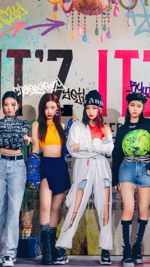 ITZY members posing in front of graffiti wall