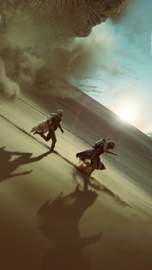 Two people running on a sand dune in Dune