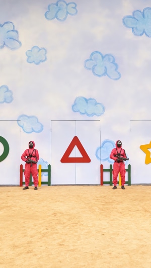 Squid Game guards in front of game symbols