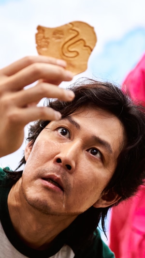 Seong Gi-hun from Squid Game holds a cookie