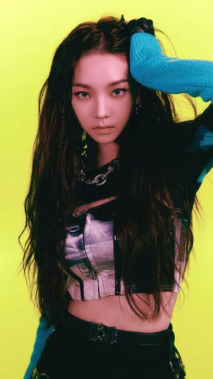 Karina from Aespa posing against a neon yellow background
