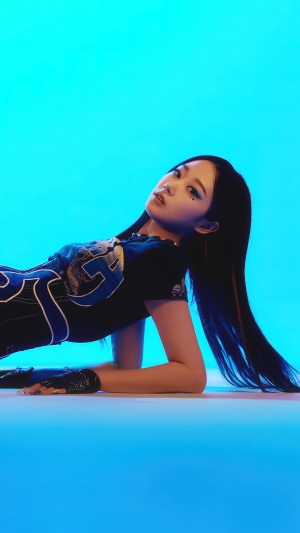 Giselle from Aespa posing on a blue background