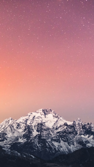 Snow-capped mountains under a starry pink sky