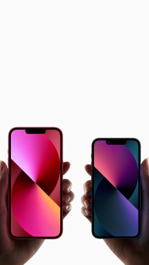 Two iPhone 13s held by hands