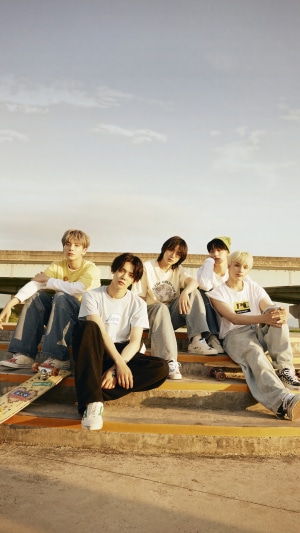 TXT members sitting on stairs with skateboards