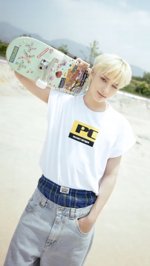 Huening Kai from TXT holding a skateboard