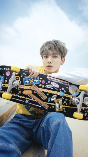 Taehyun from TXT holding a skateboard