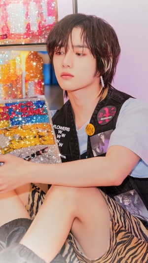 Beomgyu from TXT holding a sparkly artwork