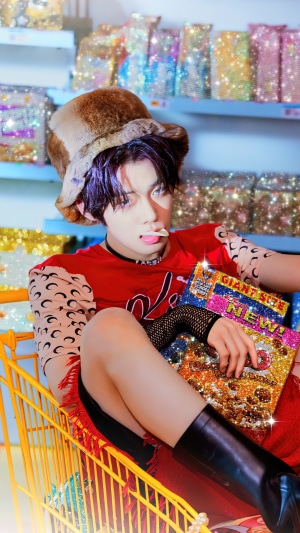 Yeonjun from TXT holding a sparkly magazine