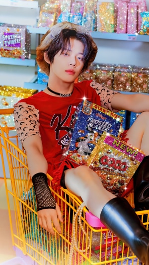 Yeonjun from TXT in a shopping cart with cereal boxes